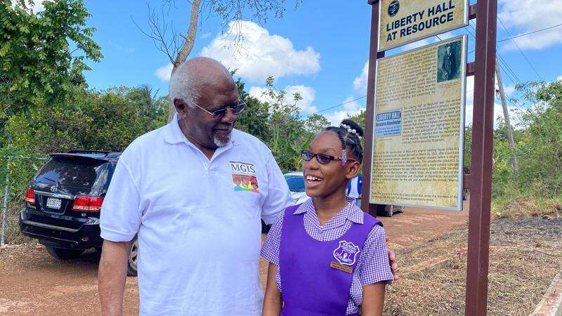 Dr Julius Garvey, son of Jamaica's first National Hero Marcus Mosiah Garvey, speaking with Octavia Taylor, deputy head girl of Kendal Primary and Infant School, last Friday. (Photo: Kasey Williams)